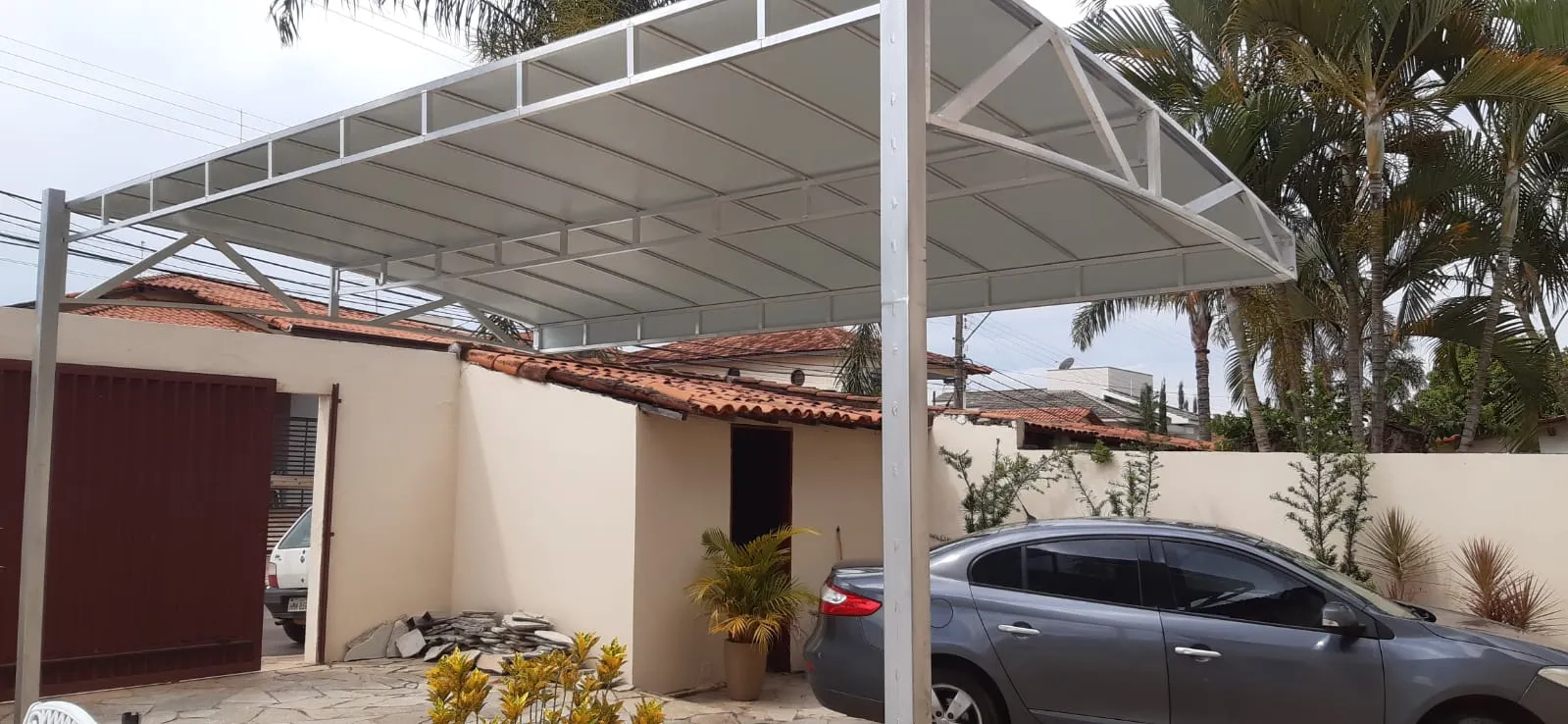 Cobertura fixa em lona cinza sobre garagem