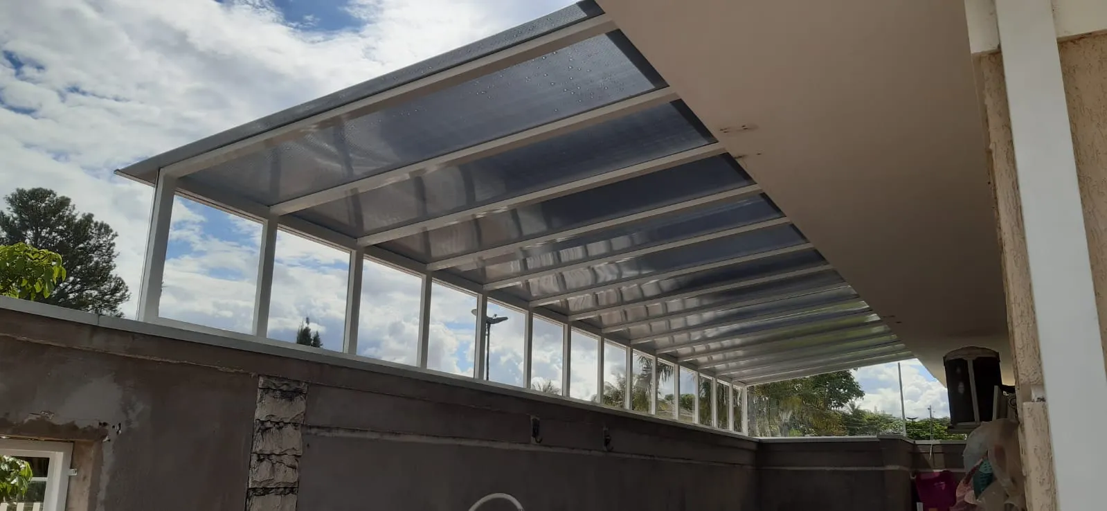 Cobertura de policarbonato cristal em área gourmet com paredes de vidro