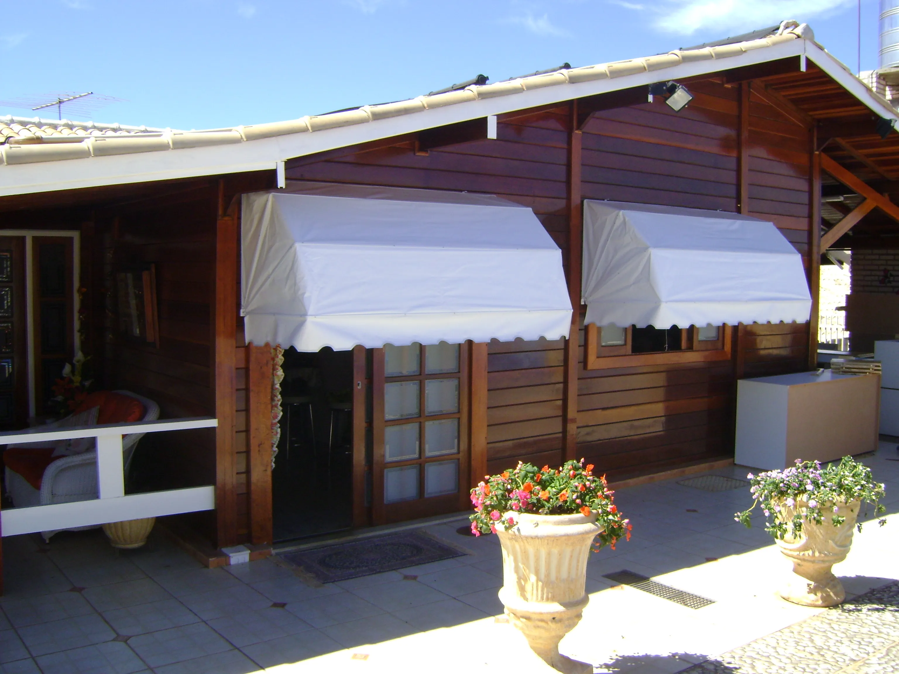 Toldos Mediterrâneo brancos em fachada de madeira com jardim