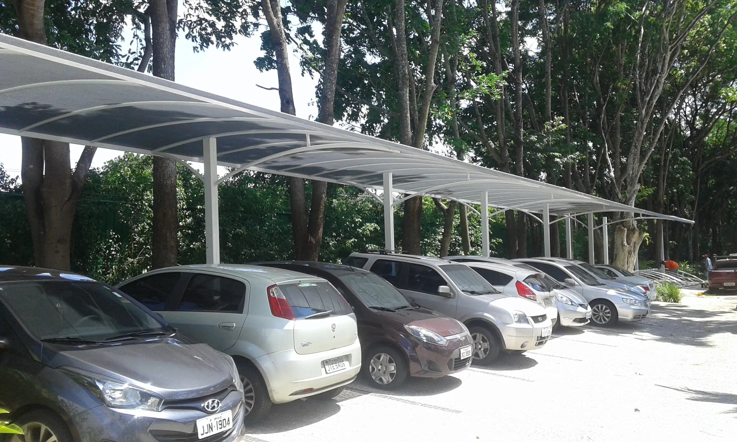Vista ampla de estacionamento com fileira de sombrites