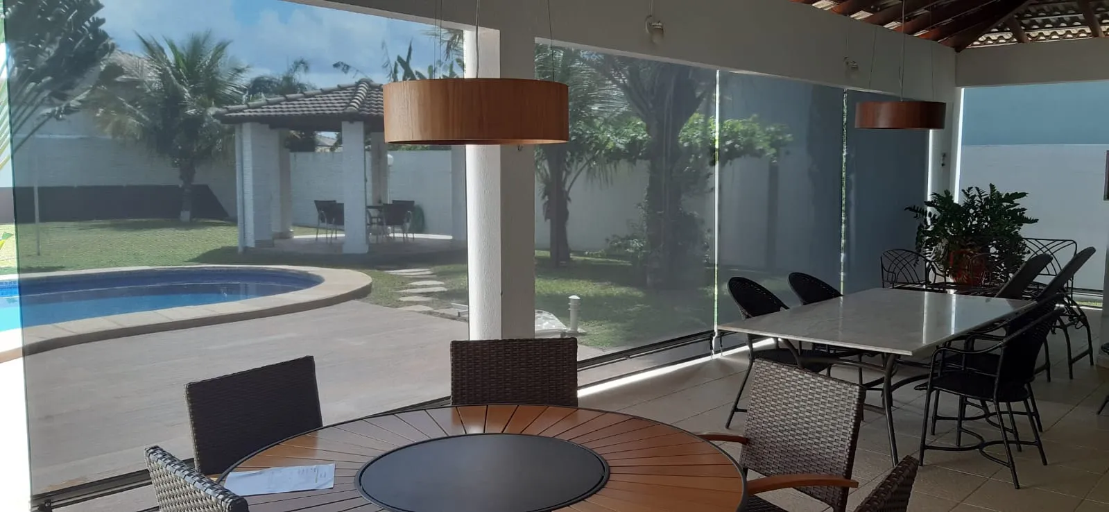 Toldo cortina com vigas de madeira e vista de piscina
