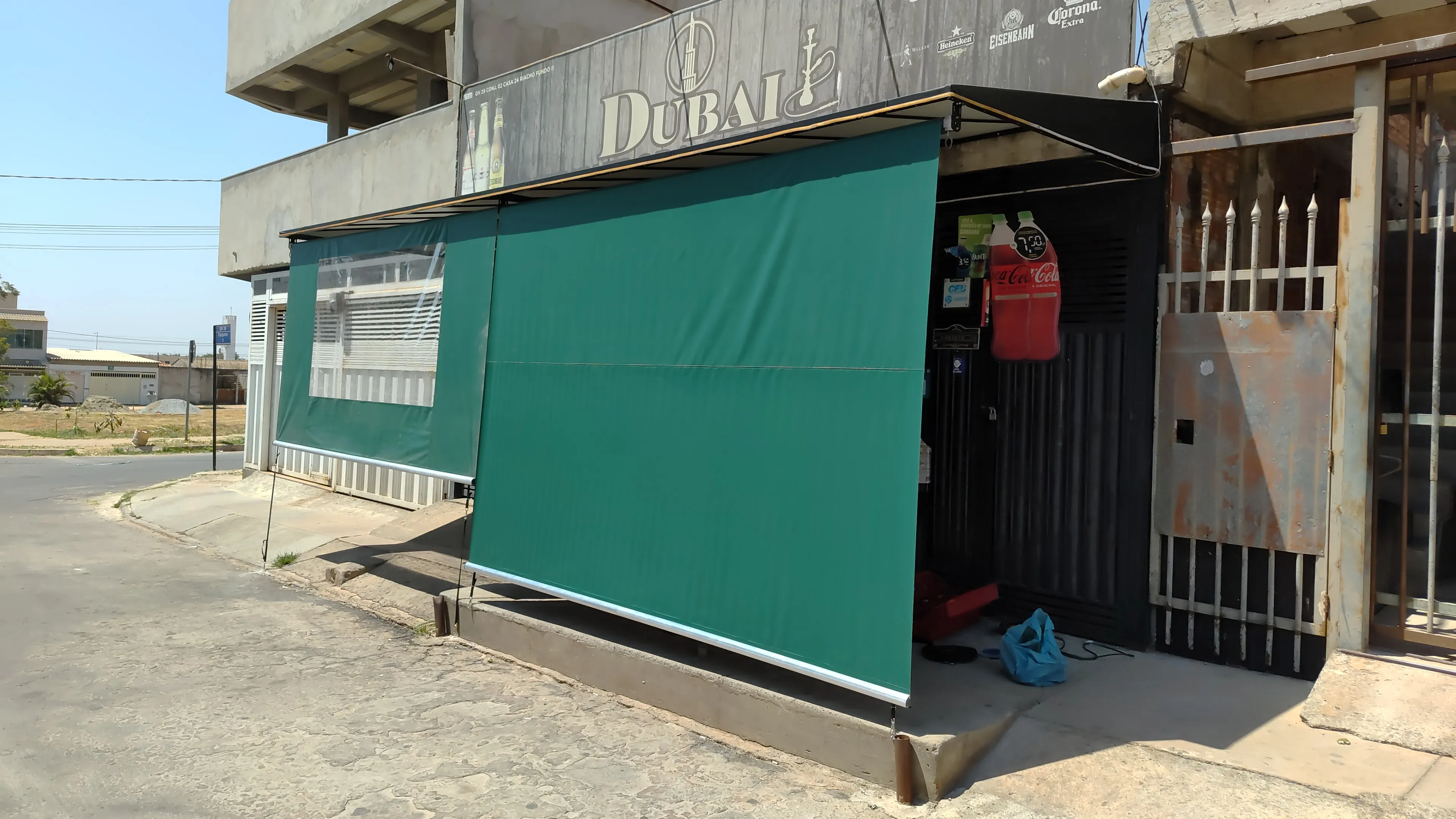 Toldo cortina verde em fachada comercial