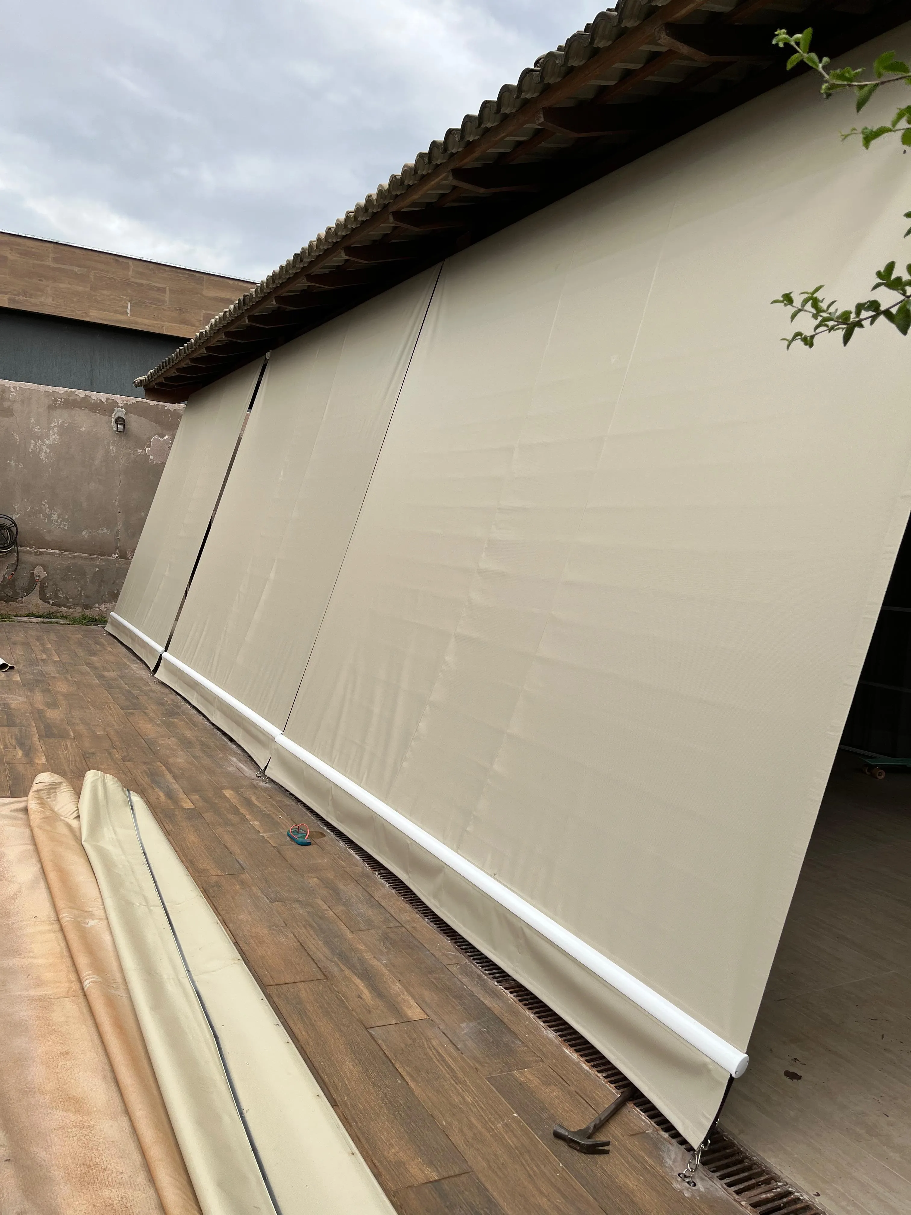 Toldo cortina creme fechado sobre deck de madeira