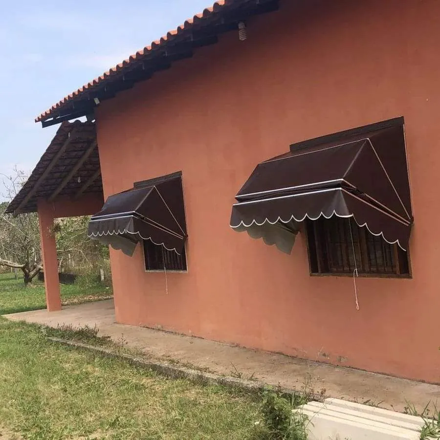 Toldos Mediterrâneo marrom-escuro em casa terracota com pergolado
