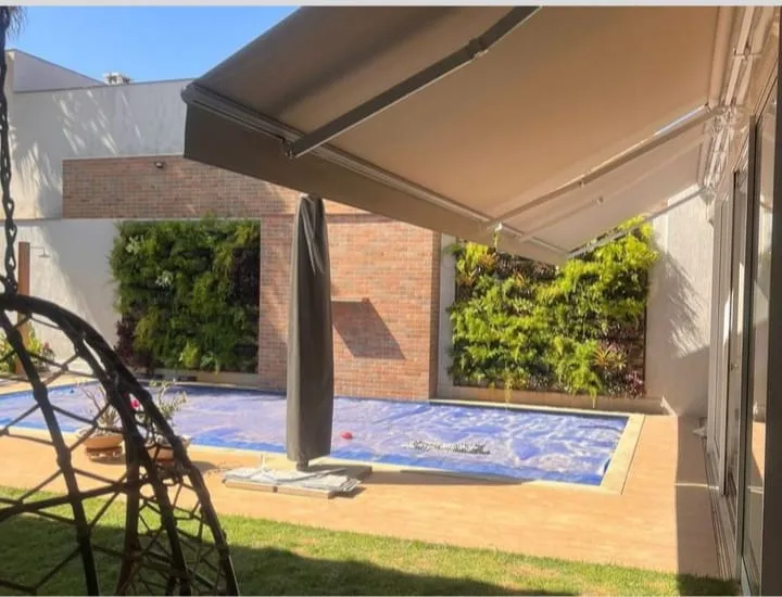 Toldo italiano articulado em residência de alto padrão com piscina